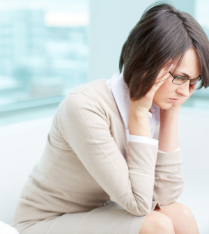 Image of a frustrated or tired young brunette rubbing temples